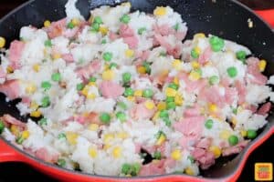 rice added to skillet with ham, peas, and corn