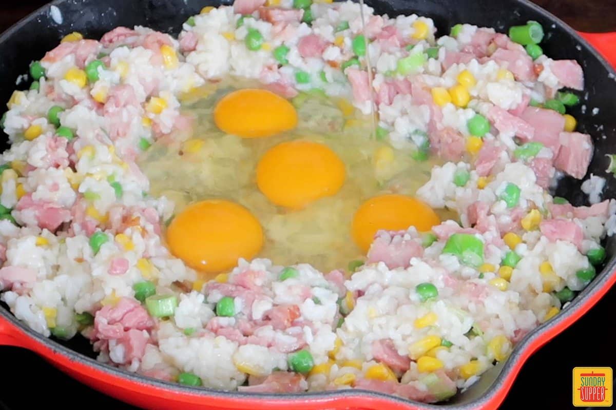 adding eggs to skillet for fried rice
