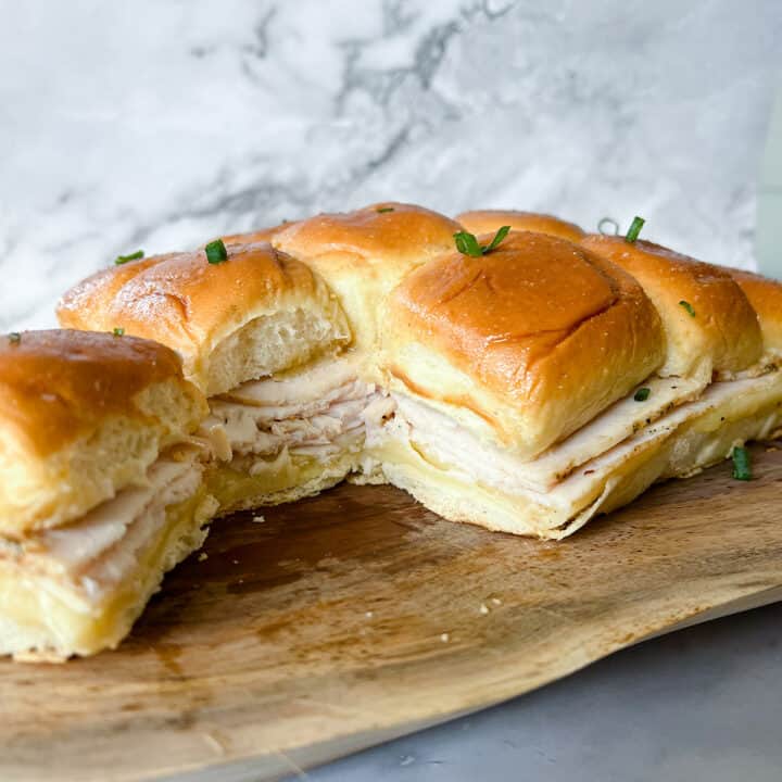 turkey and cheese sliders on a wooden serving board