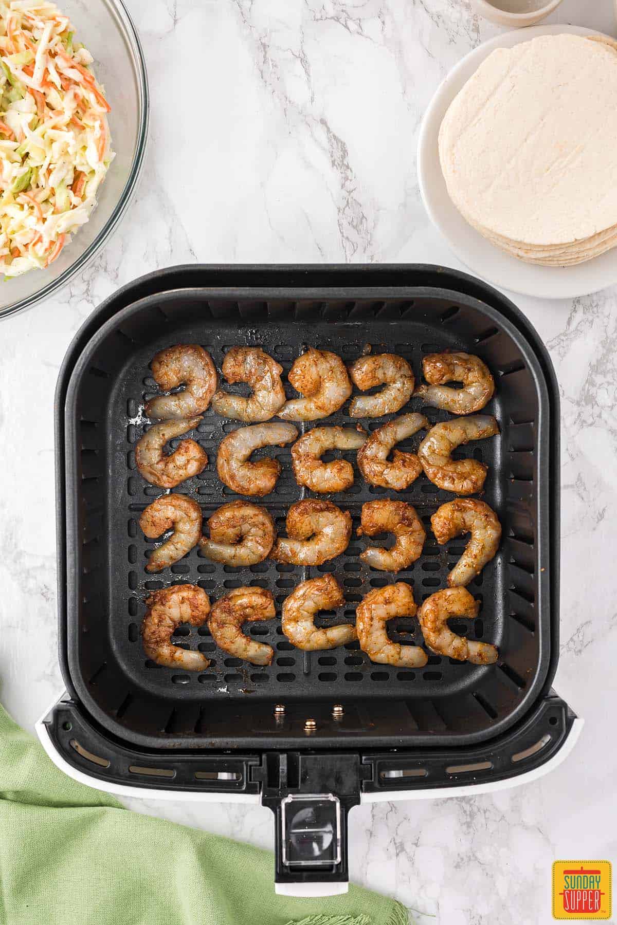 shrimp in the air fryer basket ready to cook