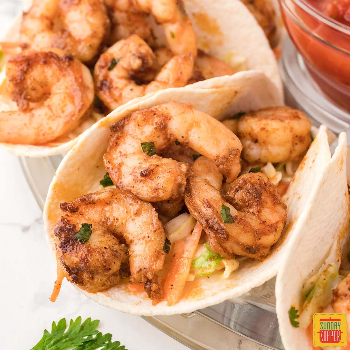 shrimp tacos up close showing air fried shrimp and slaw in tortilla shells