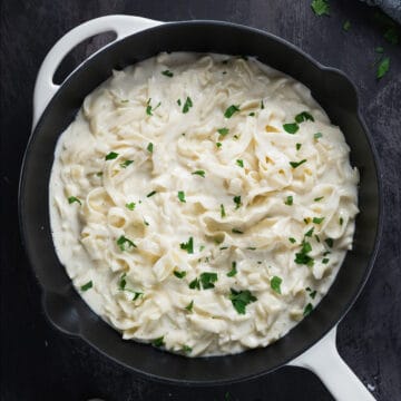 Alfredo in a skillet with fresh parsley on top