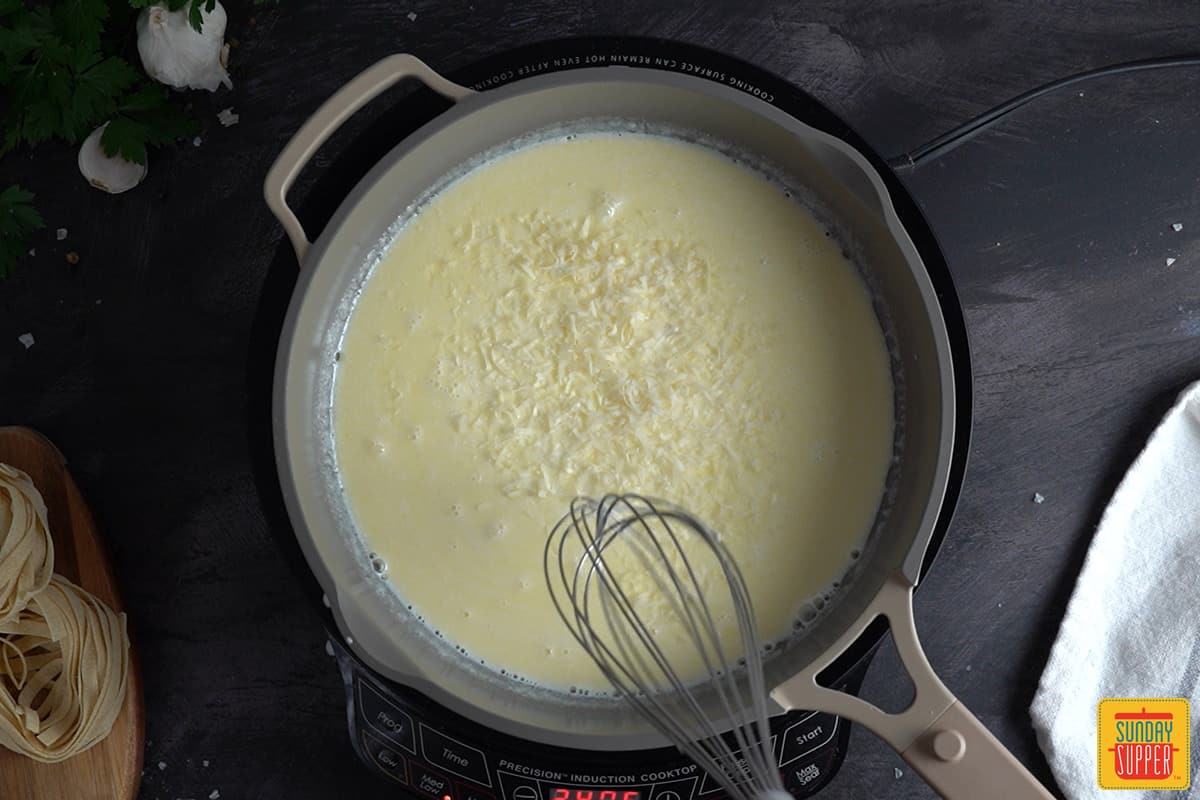 adding parmesan cheese to a skillet