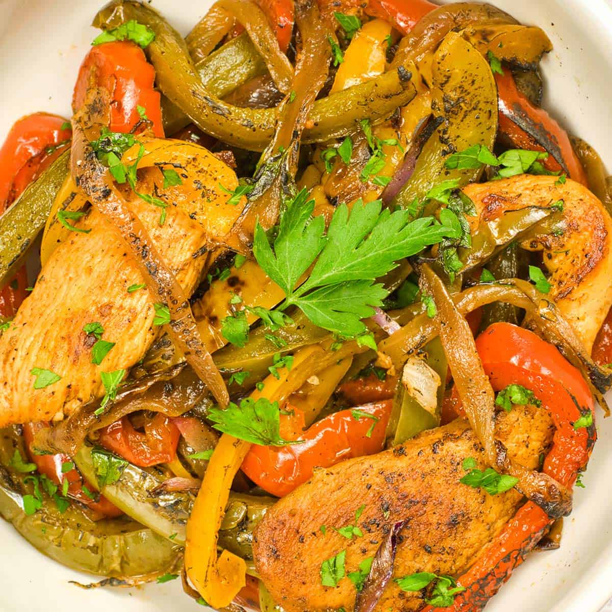 a white dish of chicken fajitas