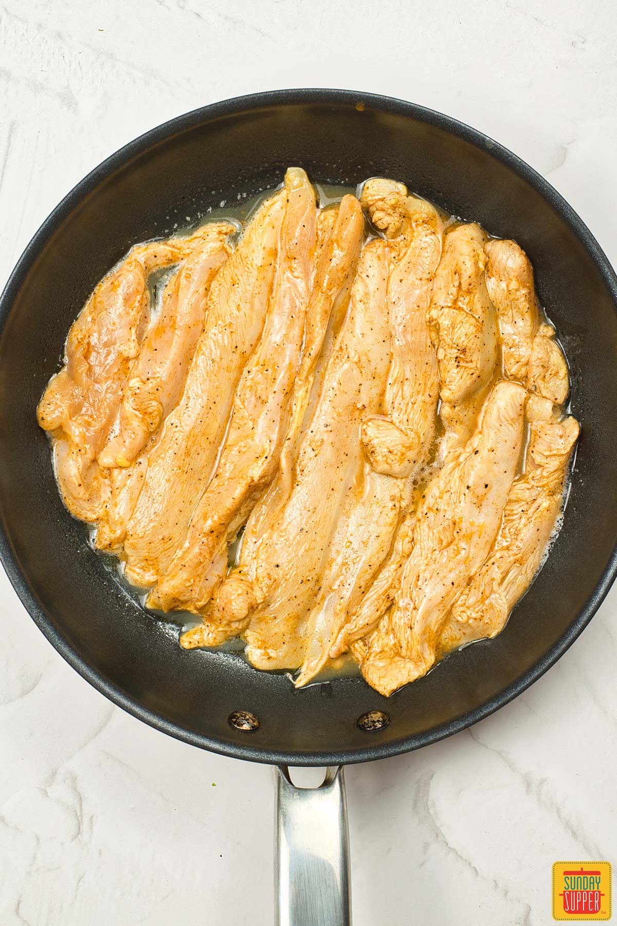 the marinated chicken placed in a pan to cook
