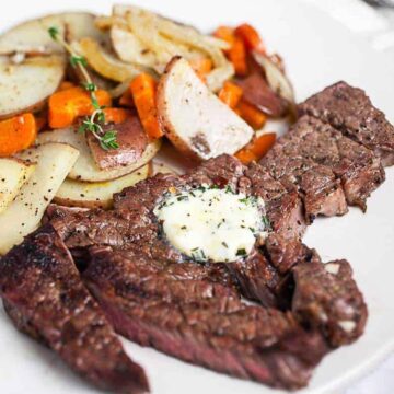 grilled chuck steak on a plate with butter and potatoes