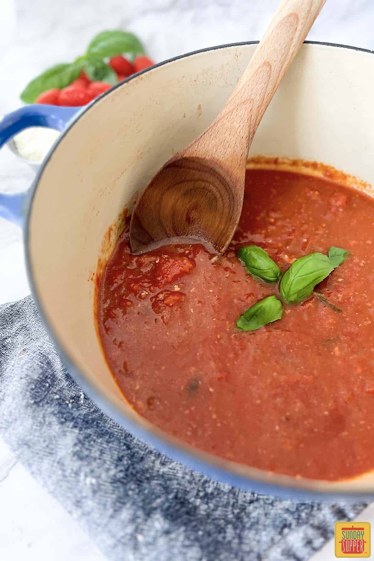 sugo recipe in a blue bowl with a spoon