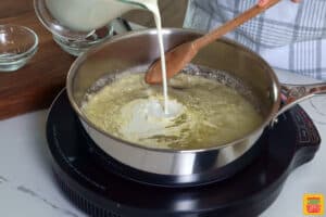 adding heavy cream into a skillet