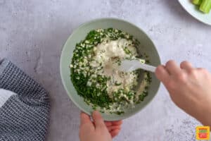 adding chives and blue cheese crumbles to blue cheese sauce