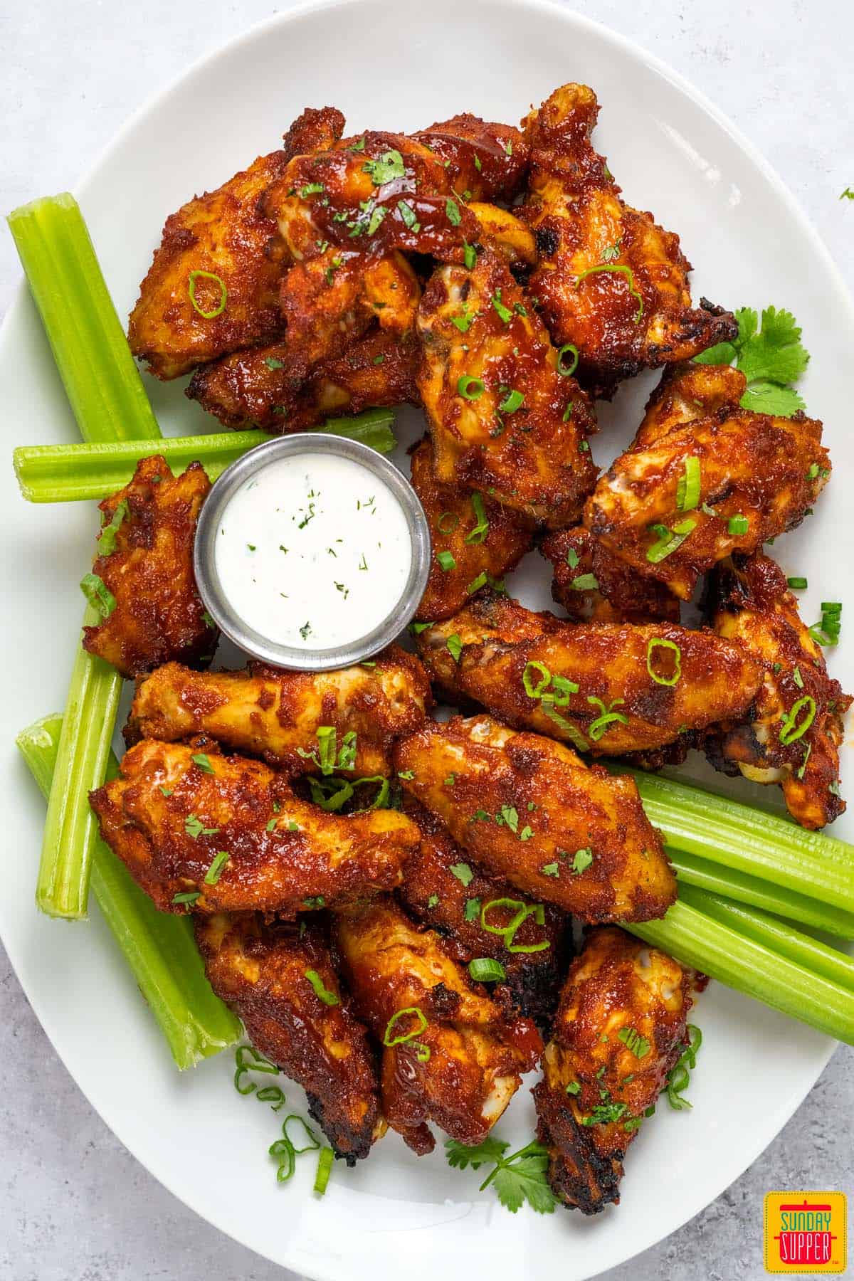 chicken wings on a plate with celery and ranch
