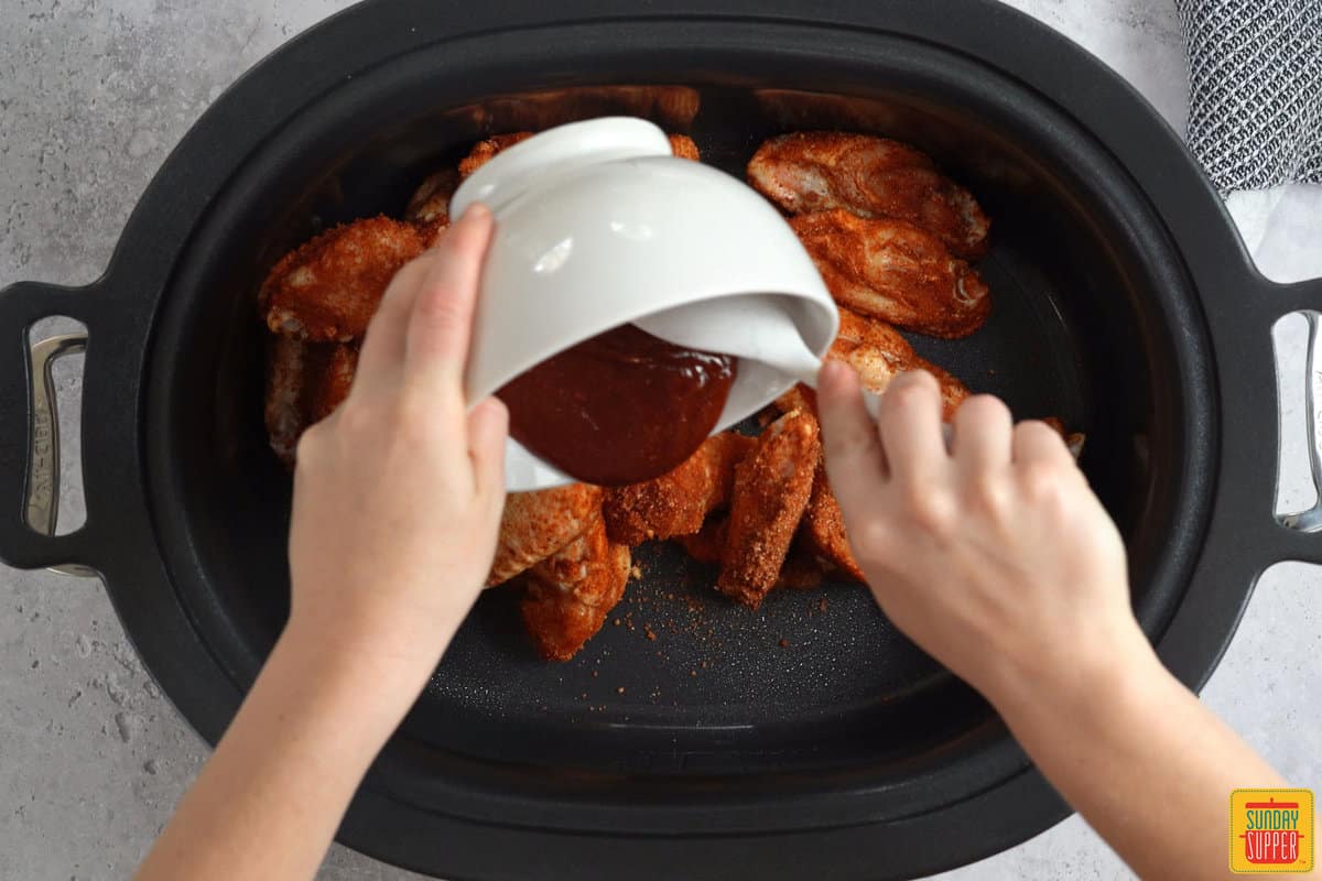 adding sauce to crock pot chicken wings