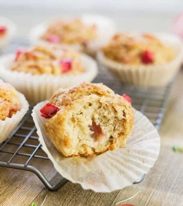 rhubarb muffins on a wood board with a bite taken out