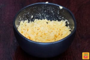 crumbled egg yolks in a black bowl