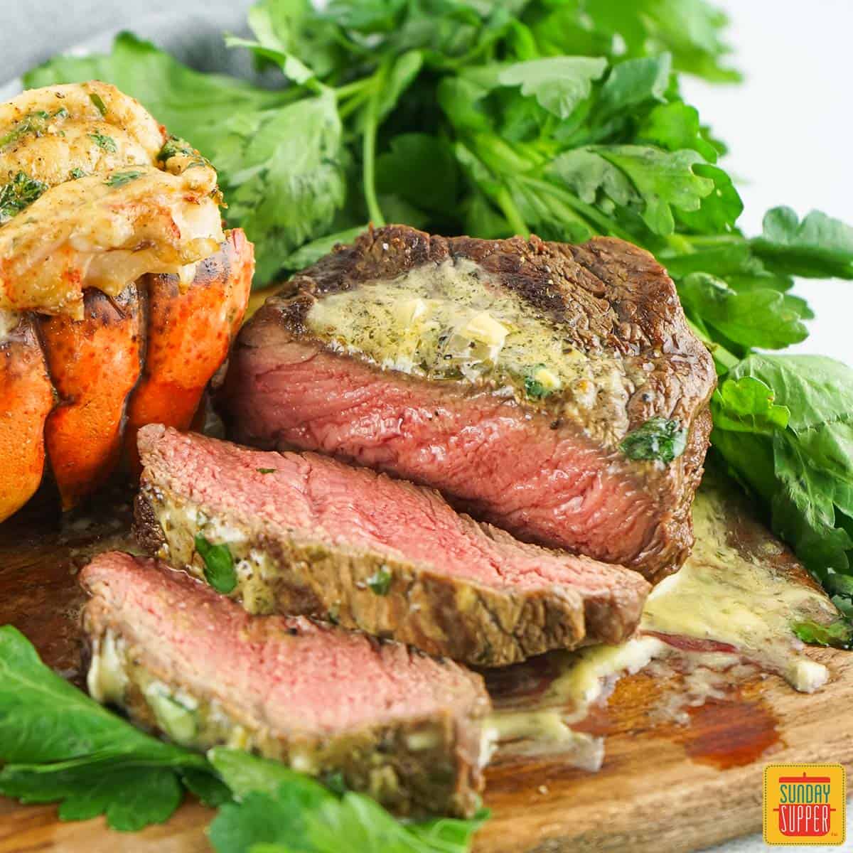 a sliced grilled filet mignon with bearnaise sauce and herbs