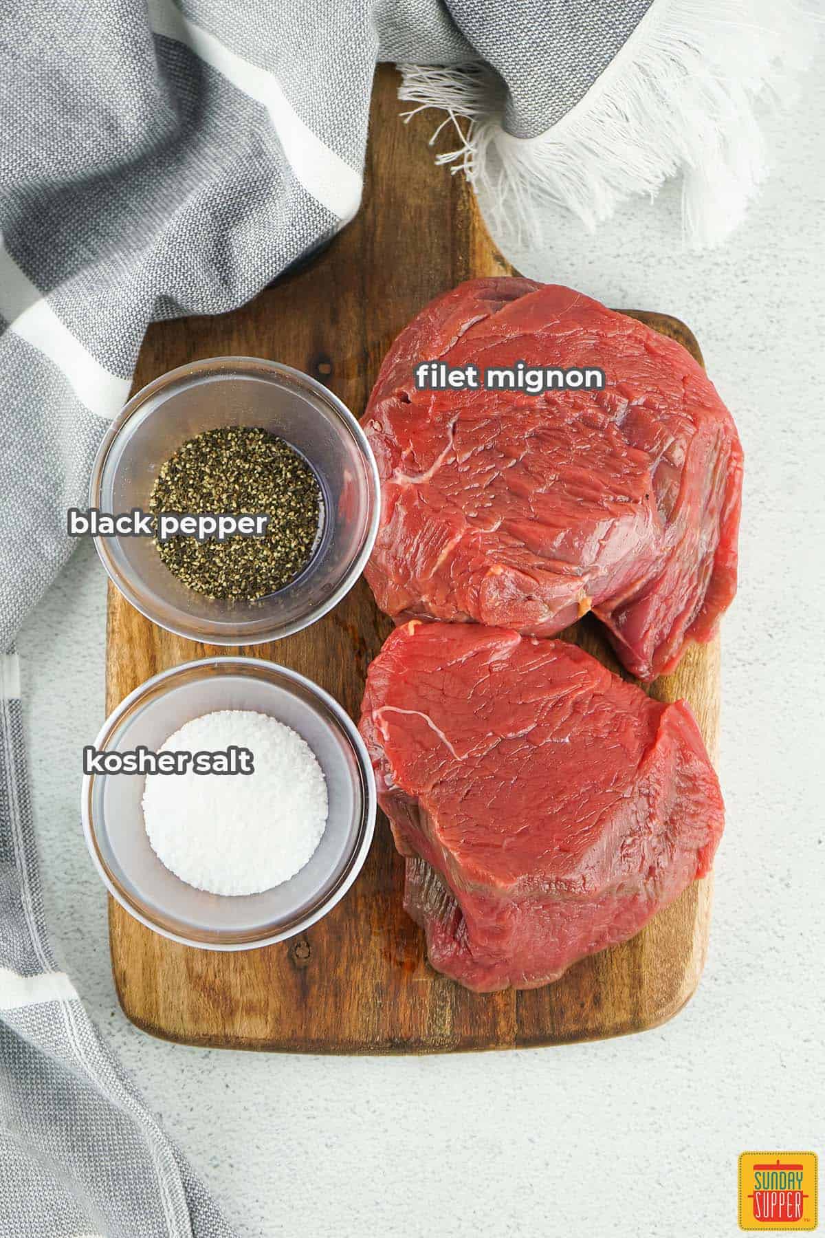 filet mignon, salt, and pepper on a cutting board with labels