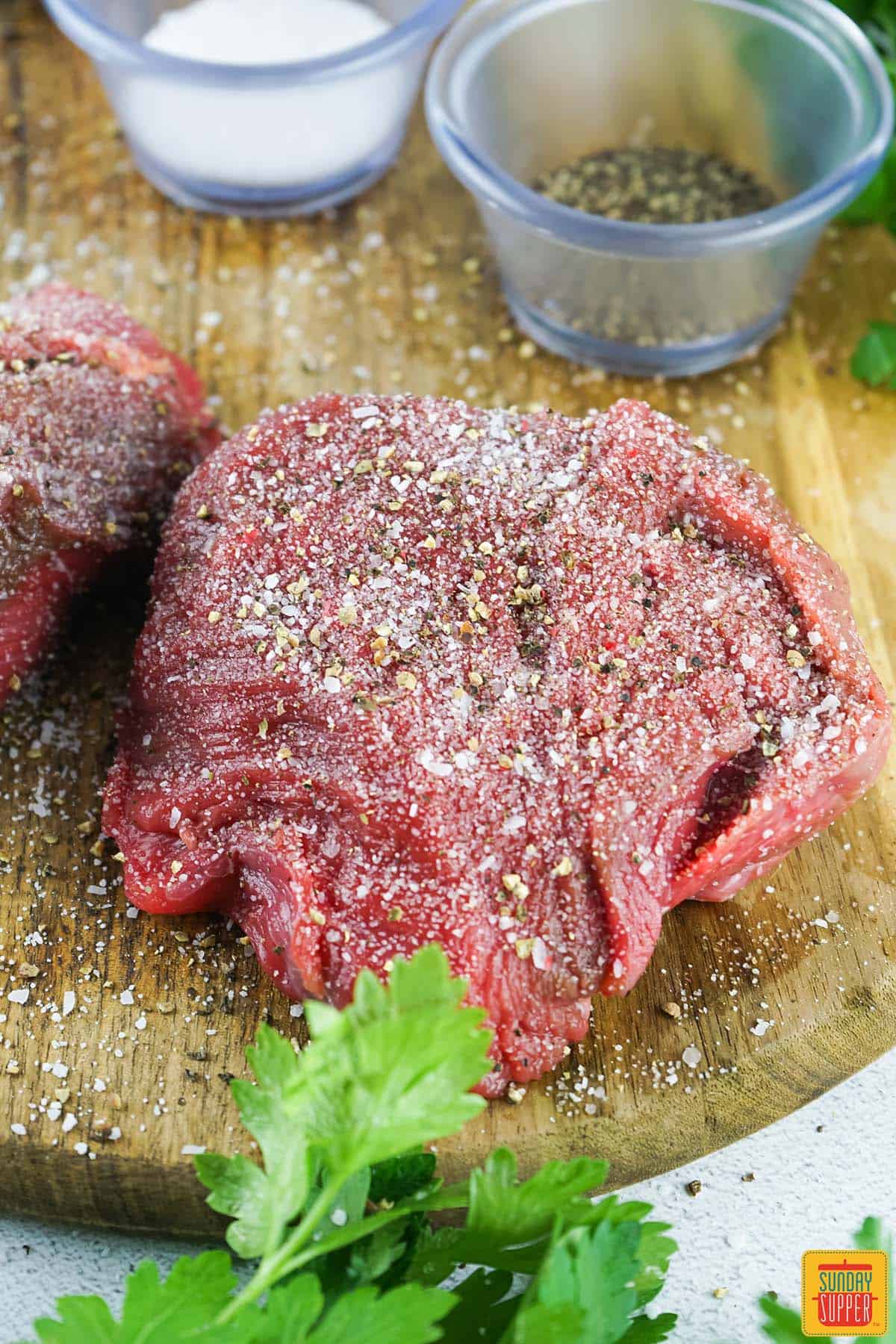 seasoned filet mignon resting on a cutting board