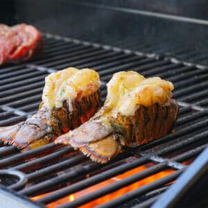 two lobster tails cooking on the grill