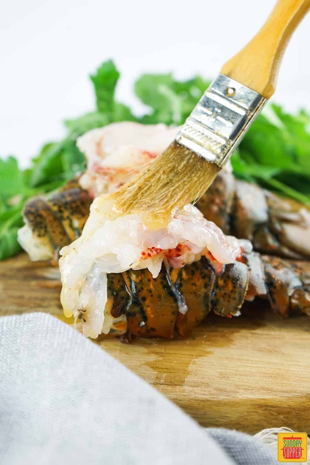 brushing a lobster tail with butter