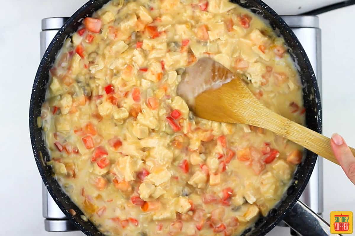 the chicken, vegetables, and soups all mixed together in a pan