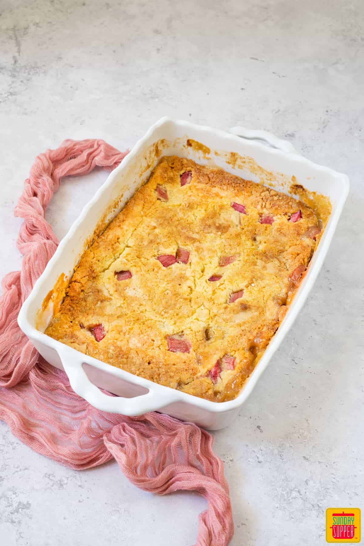 rhubarb dump cake in a white baking dish on the table