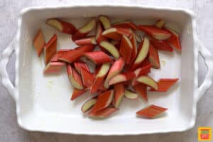 slices of rhubarb on the bottom of a white baking dish