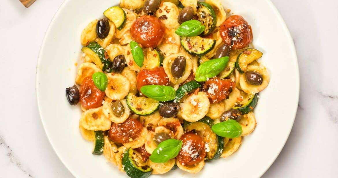 orecchiette pasta salad with tomatoes and basil in a deep white plate