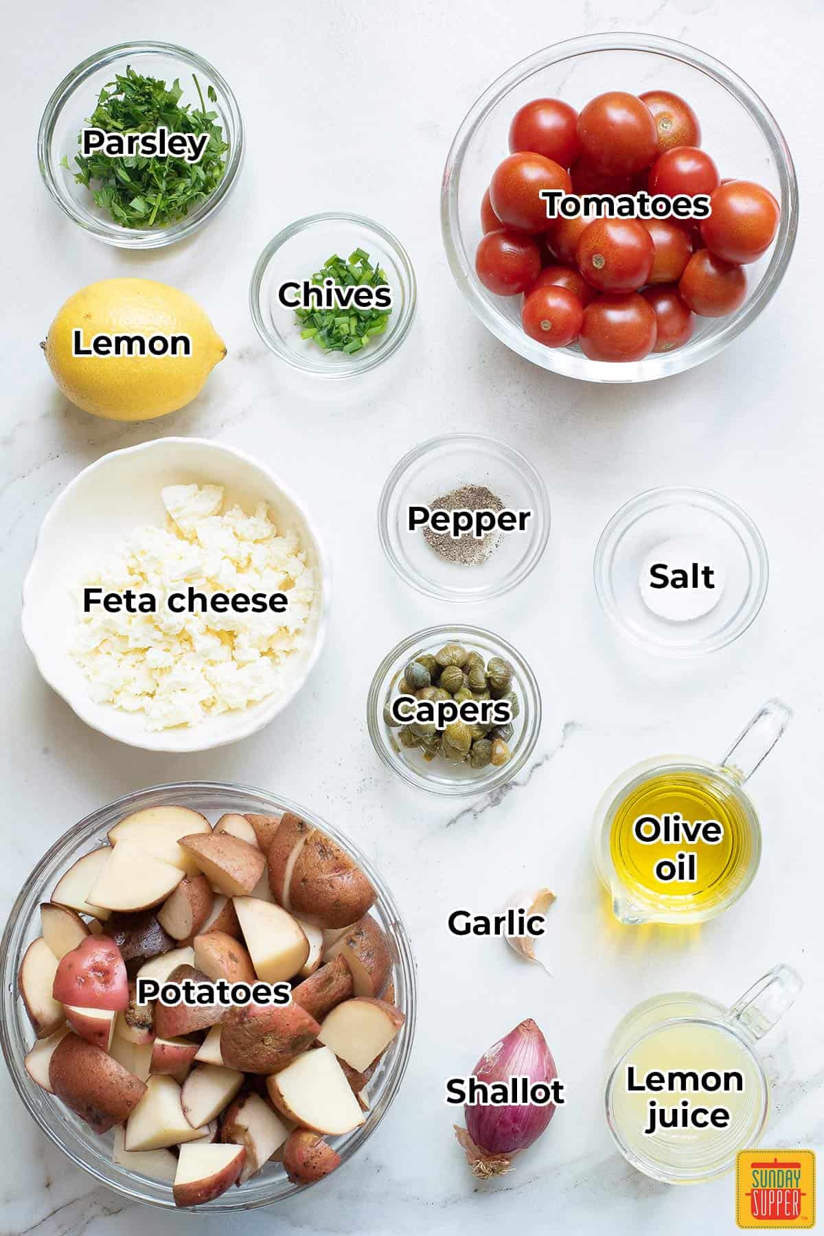 all the ingredients for Mediterranean Potato Salad in separate bowls with labels