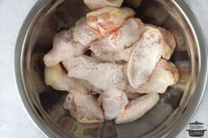mixing chicken wings with breading ingredients