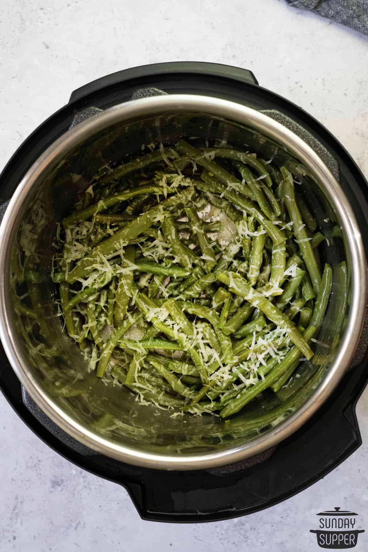 green beans inside the instant pot with shredded cheese