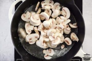 sautéing mushroom in a pan
