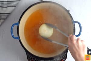 adding an onion to boiling water