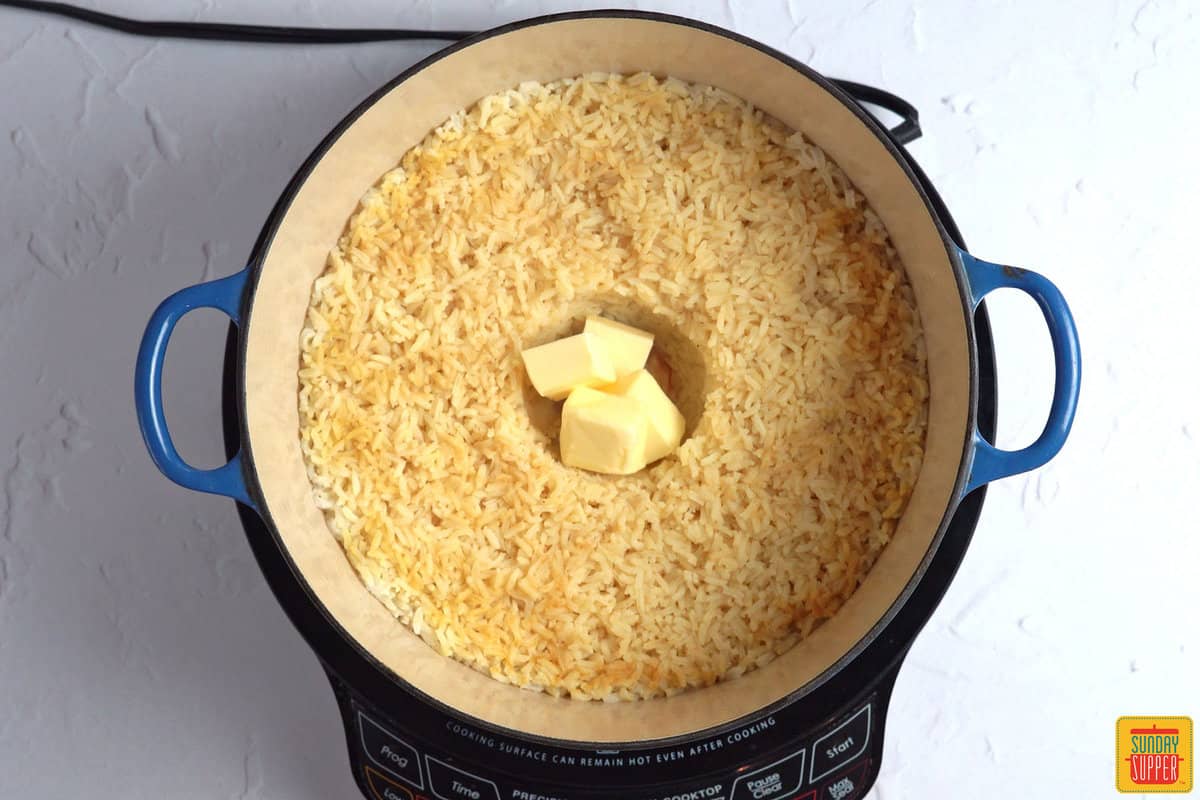 adding butter to pot of rice