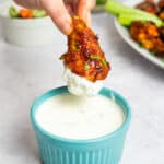 chicken wing dipping into ranch dressing