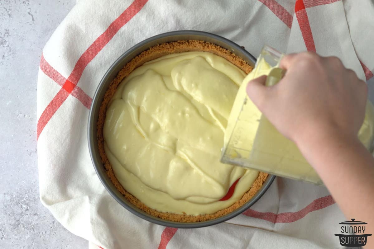 pouring remaining cheesecake mixture into pan