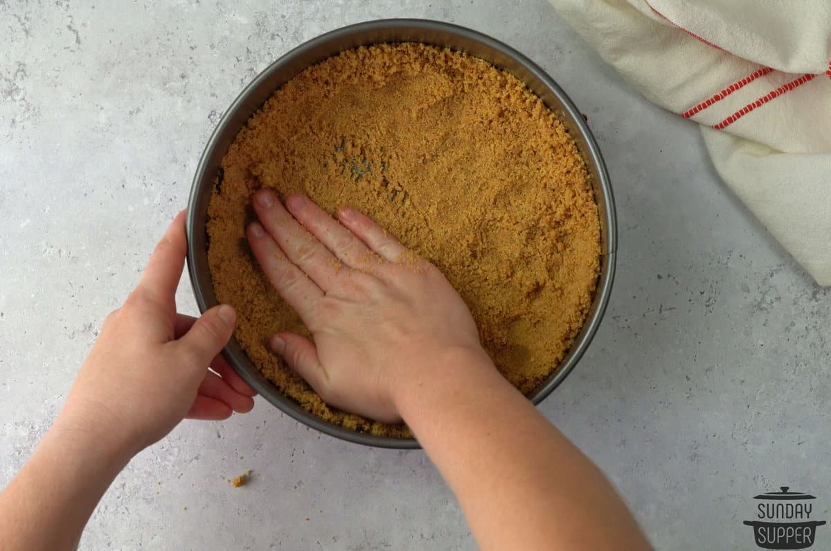 pressing graham cracker crush into pan