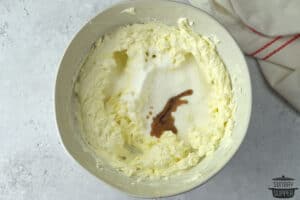 sugar and vanilla extract over beaten cream cheese