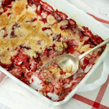 strawberry dump cake with a serving spoon in a baking dish