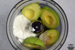 ingredients to make avocado crema added to a food processor