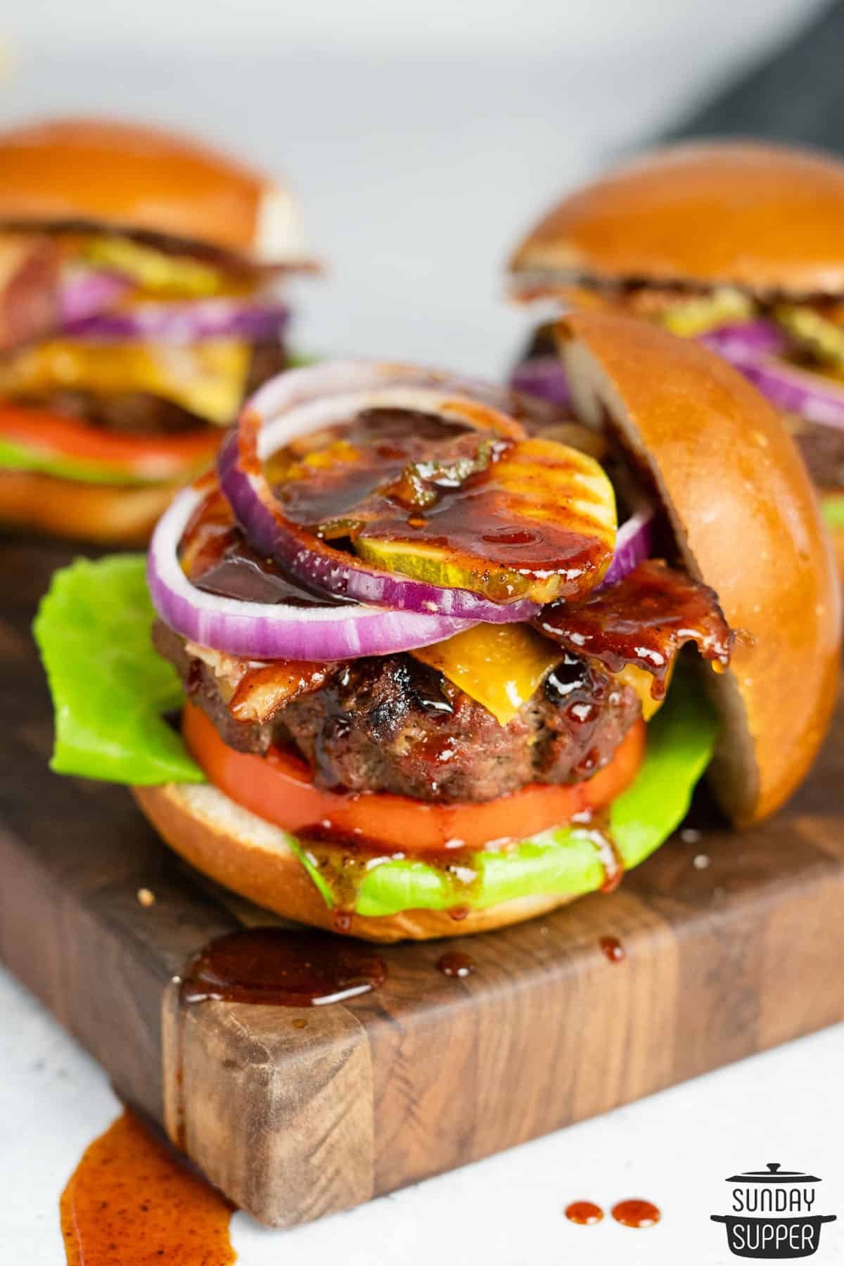bbq hamburger on a serving board with dripping bbq sauce