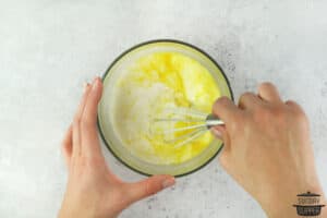 whisking eggs with cream in a bowl