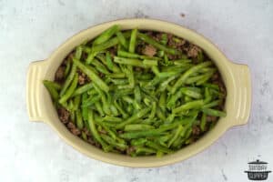 adding frozen green beans to the casserole dish