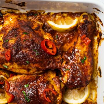close up of peri peri chicken inside of a baking dish