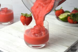 pouring strawberry daiquiri into a glass