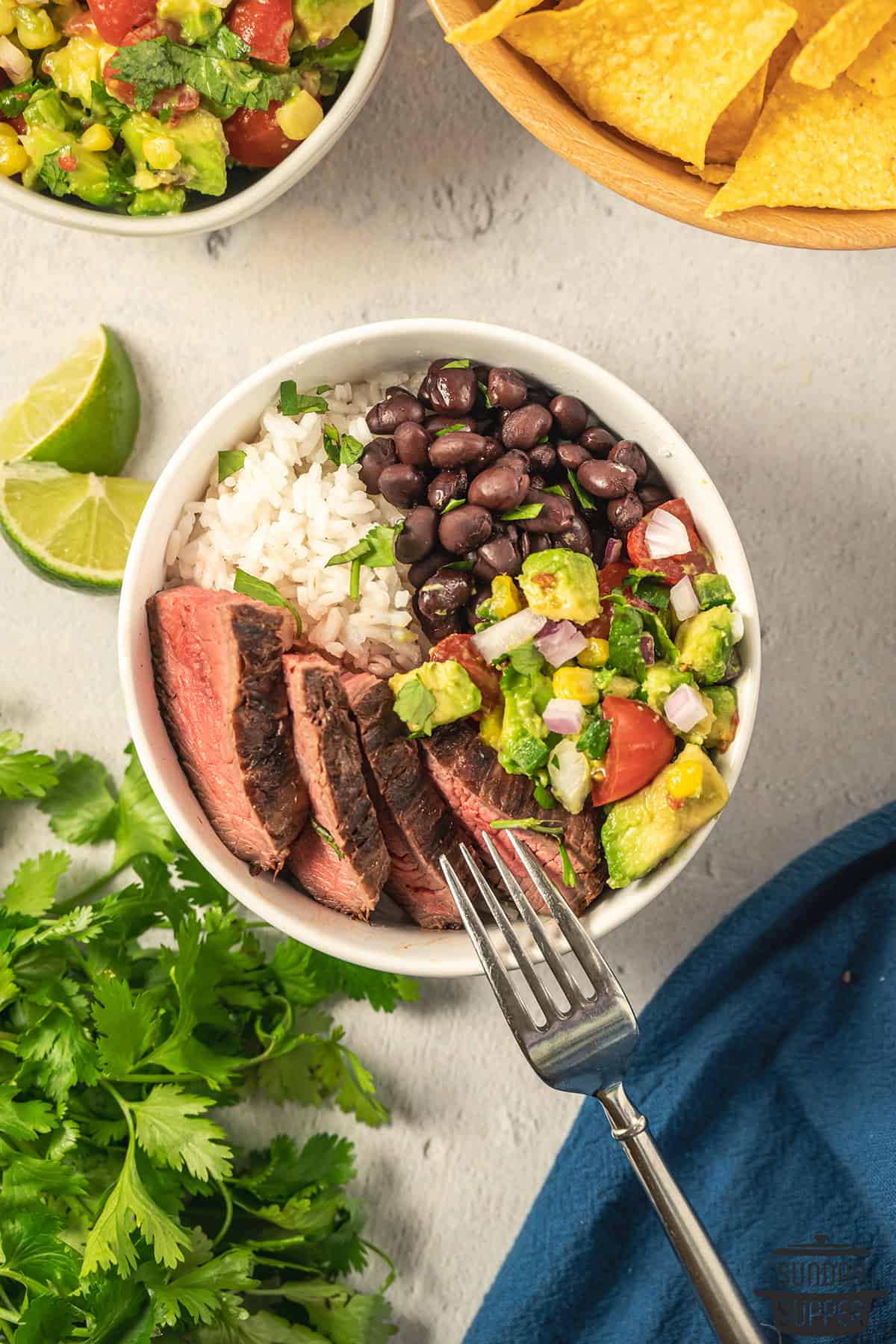 bowl with flank steak, beans, avocado salsa, and rice