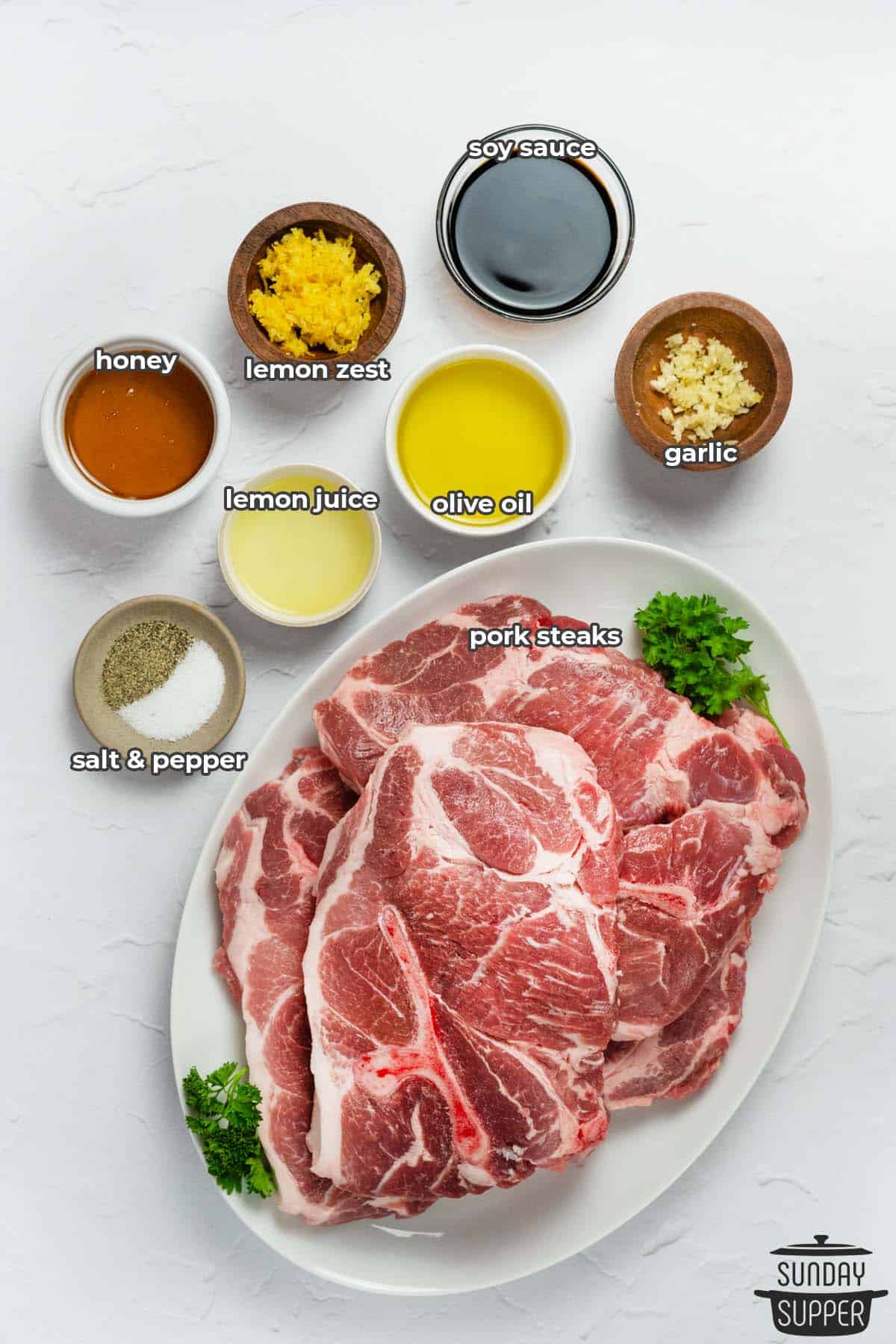all the ingredients for grilled pork steaks in separate bowls with labels