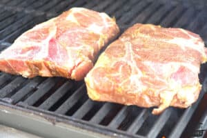 the marinated pork steaks set on a grill