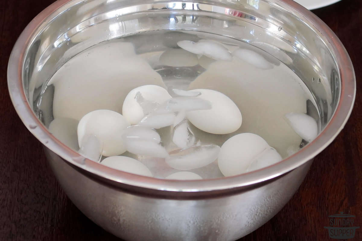 hard boiled eggs cooling in a pot of ice water