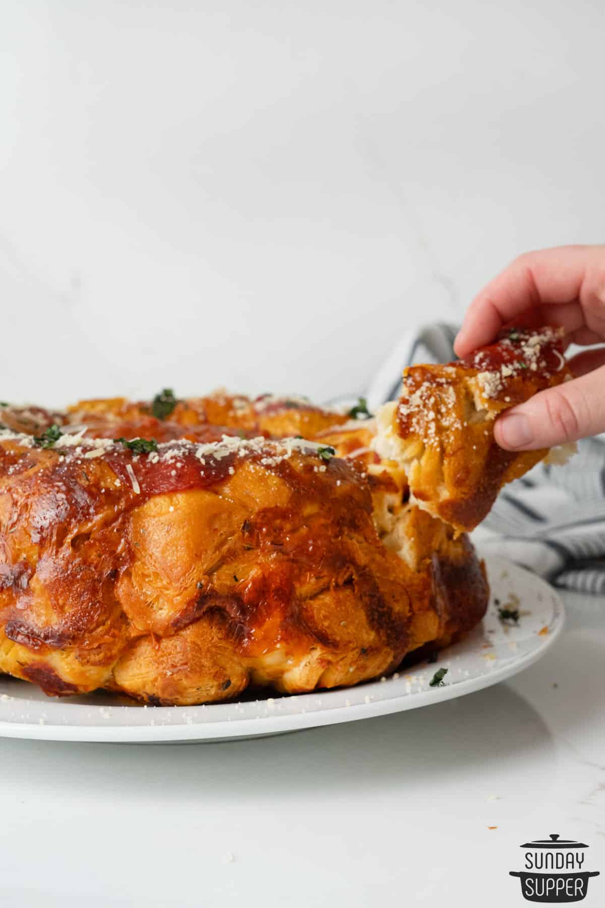 pulling apart pizza monkey bread on a plate