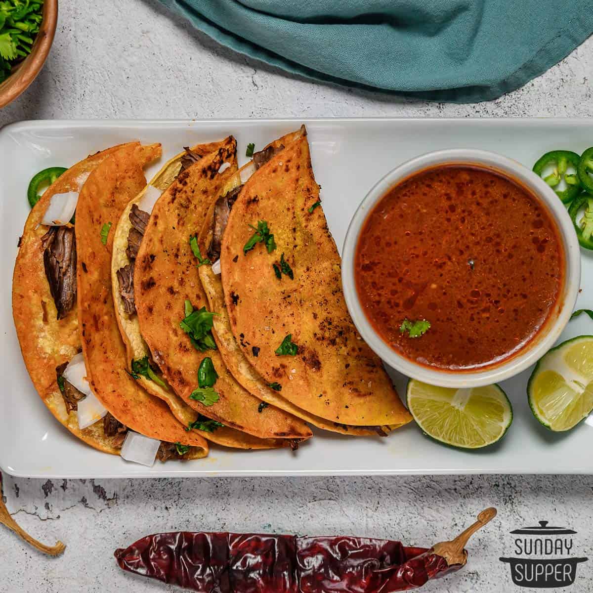 quesabirria tacos on a plate with birria consome dip