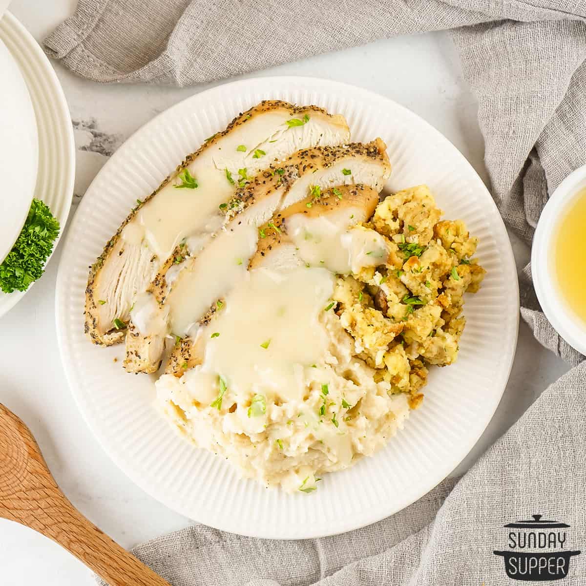 a plate with turkey breast, stuffing, and mashed potatoes covered in turkey gravy